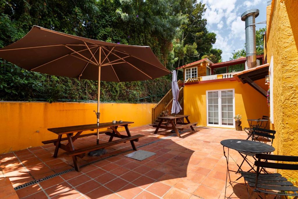 Pátio exterior com mesas de piquenique e guarda-sol
