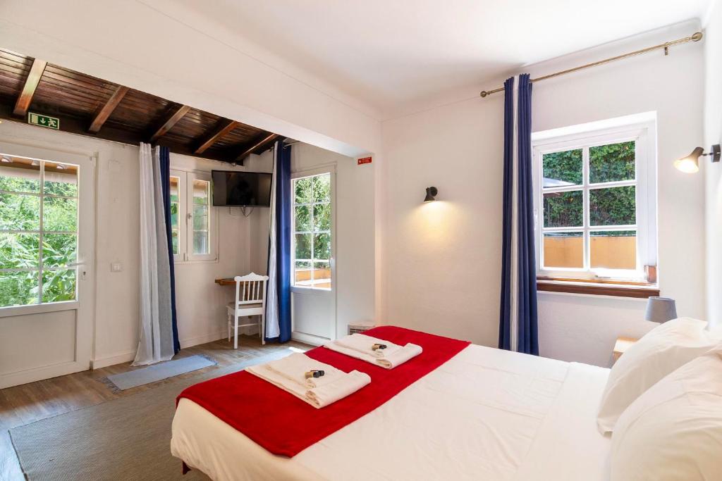 Quarto duplo com tecto em vigas de madeira e luz natural