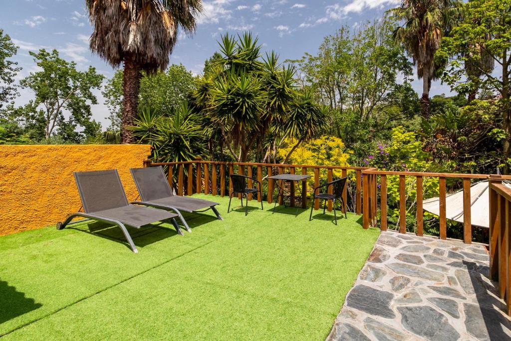 Terraço relvado com espreguiçadeiras e vista sobre o jardim