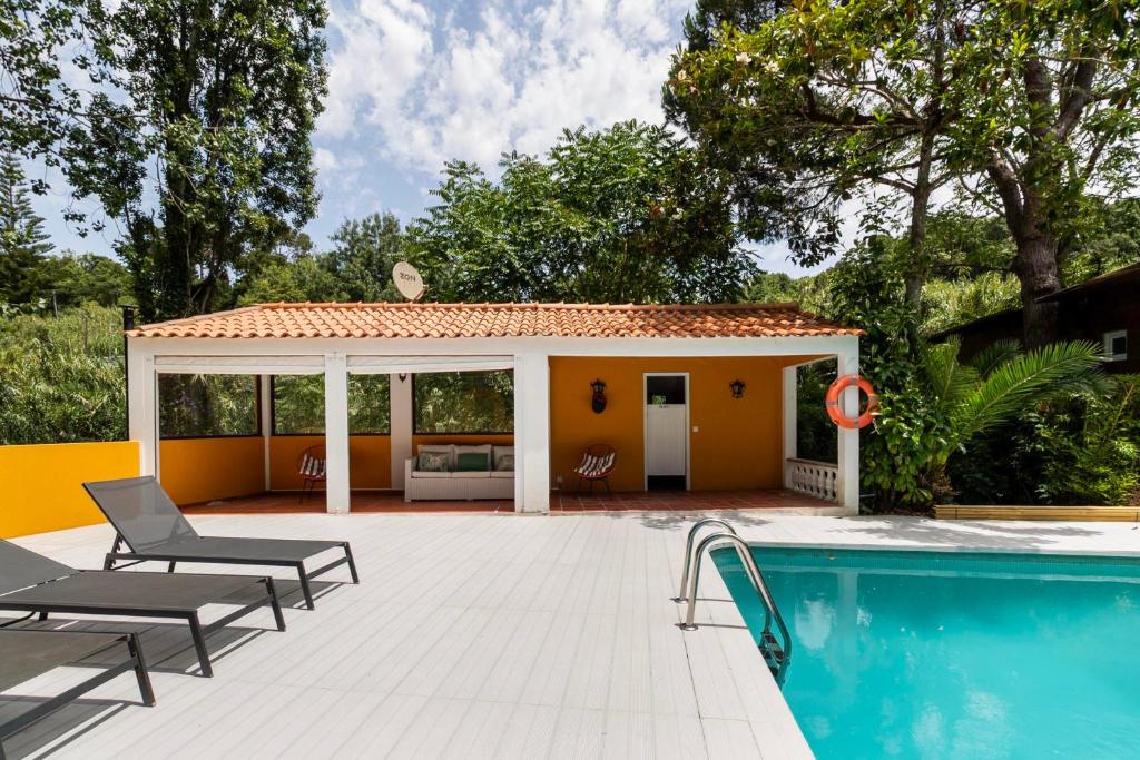 Piscina exterior com pool house e espreguiçadeiras
