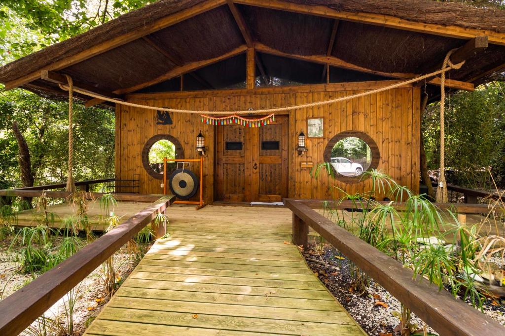 Dojo em madeira com passadiço de acesso e jardim