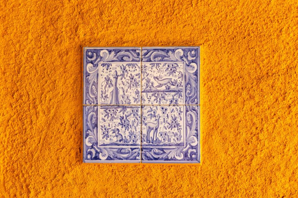 Painel de azulejos tradicional em parede amarela