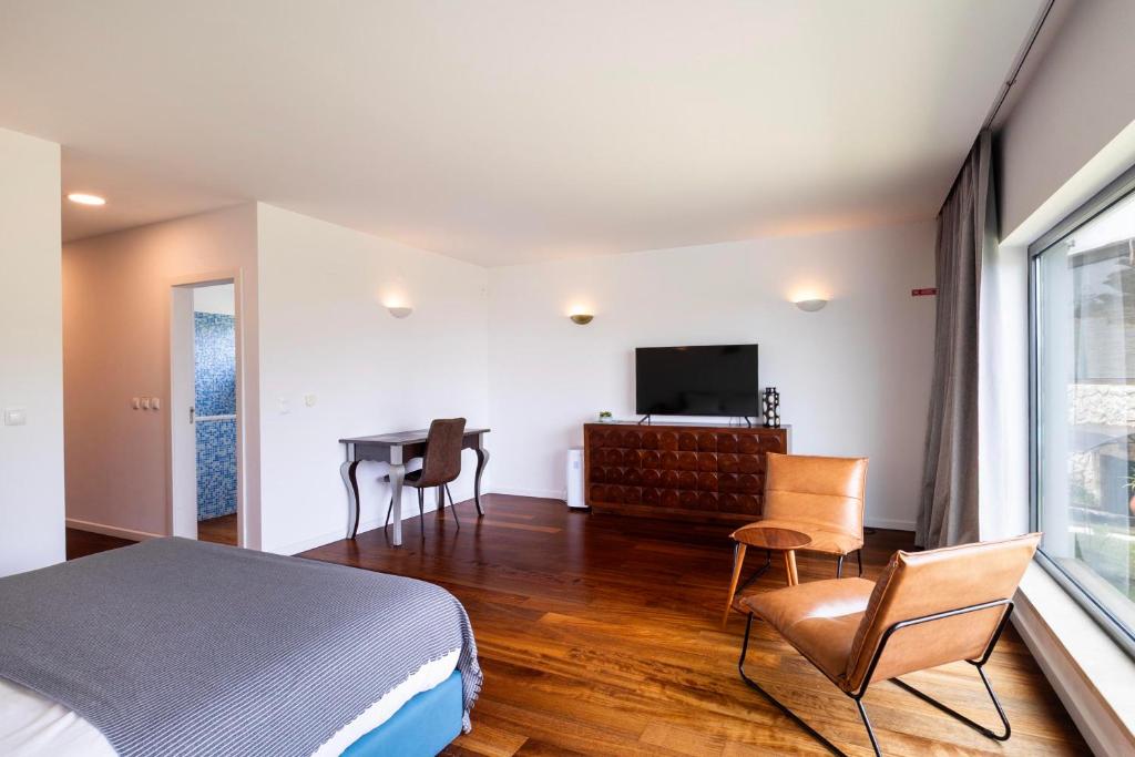 Zona de quarto com TV, secretária e área de estar