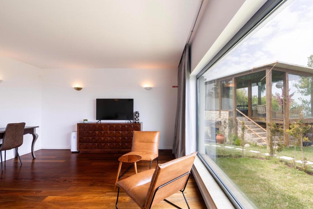 Sala de estar privativa com TV e vista para o jardim
