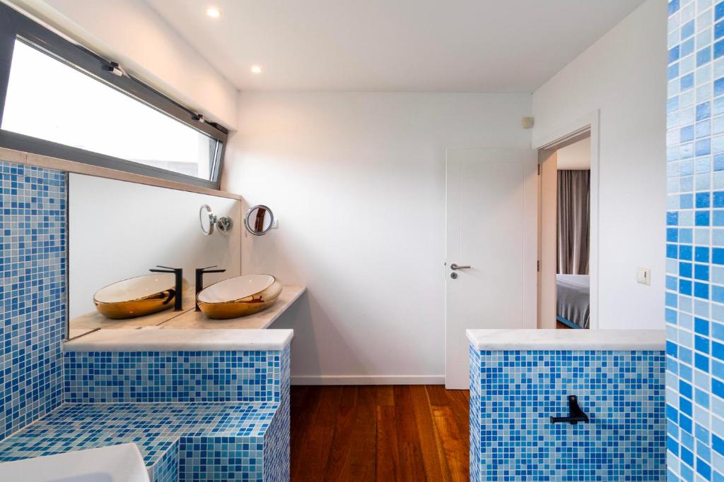 Casa de banho com duplo lavatório e mosaico azul