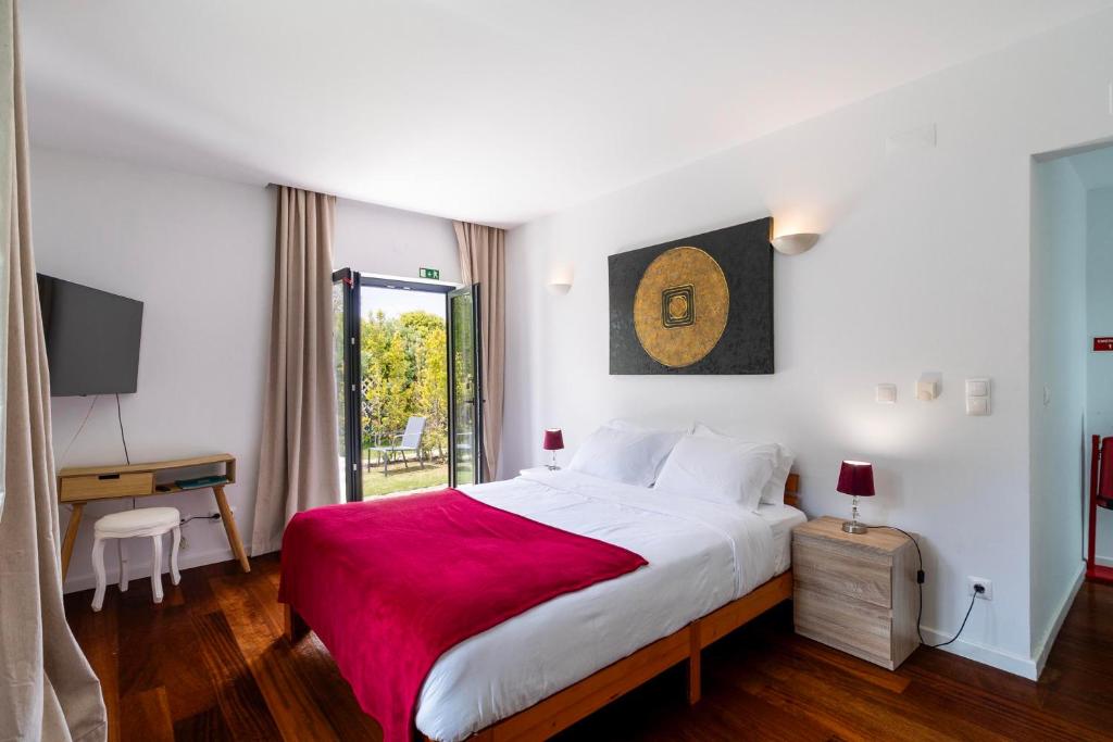 Suite com cama de casal, obra de arte e acesso ao jardim