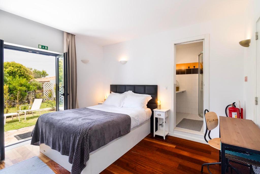 Suite com cama de casal e porta envidraçada para o jardim