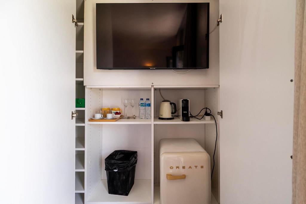 Armário com TV, frigorífico, chaleira e máquina de café