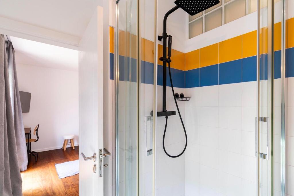 Casa de banho com duche e azulejo azul e amarelo