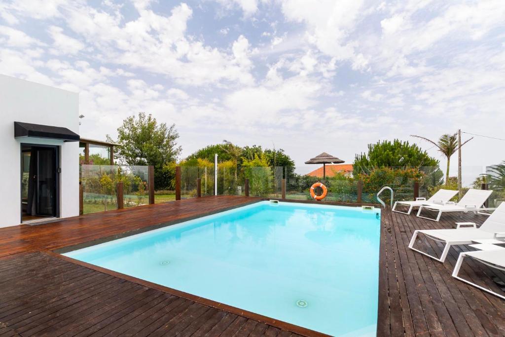 Piscina exterior com deck em madeira e espreguiçadeiras
