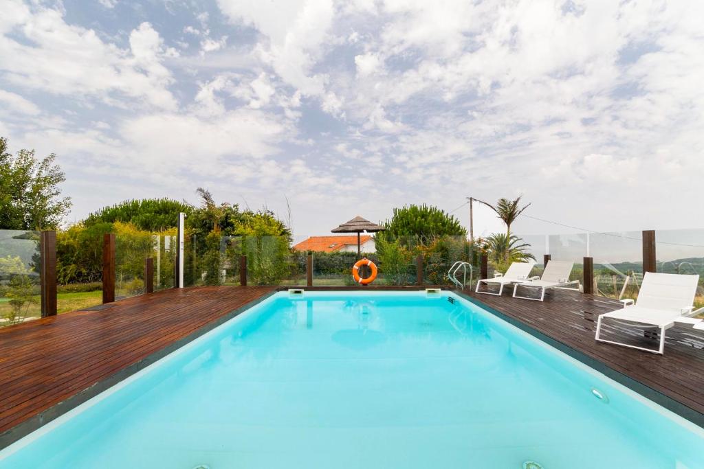 Piscina com deck em madeira e vista sobre o campo