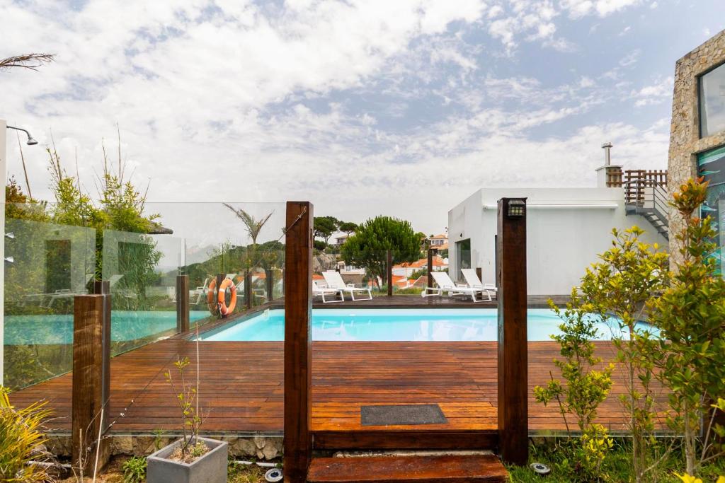 Piscina com guarda-corpo em vidro e deck em madeira