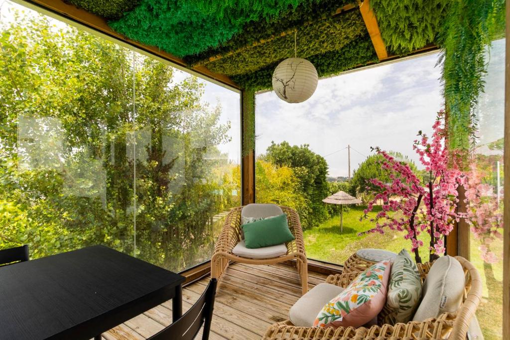 Pavilhão envidraçado com sofás e vista para o jardim