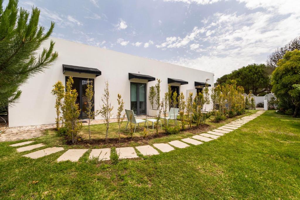 Fachada das suites com jardim e caminho de pedra
